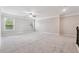 Large, open bonus room has neutral carpet, a ceiling fan, and natural light from two windows at 4090 Danbury Farms Dr, Cumming, GA 30040