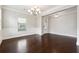 Elegant dining room with dark hardwood floors, white wainscoting, and a chandelier at 4090 Danbury Farms Dr, Cumming, GA 30040