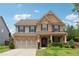 Charming two-story brick home with a well-manicured lawn and a two-car garage at 4090 Danbury Farms Dr, Cumming, GA 30040