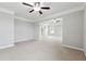The main bedroom boasts tray ceilings, a ceiling fan, and view of adjacent rooms at 4090 Danbury Farms Dr, Cumming, GA 30040