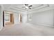 The main bedroom features a tray ceiling, ceiling fan, and doorway to an en-suite bathroom at 4090 Danbury Farms Dr, Cumming, GA 30040