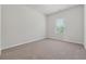 Clean and bright bedroom with plush carpet, window, and neutral paint at 2182 Talmai Dr, Snellville, GA 30078