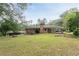 Spacious backyard view of brick home with covered area, fire pit, and mature landscaping at 2614 Princess Se Ln, Marietta, GA 30067