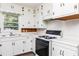 Cozy kitchen featuring white cabinets, laminate countertops, a gas range, and a window with natural light at 2614 Princess Se Ln, Marietta, GA 30067