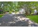 Long driveway leading to a two-car garage, surrounded by trees and landscaping at 350 Westchester Way, Canton, GA 30115