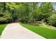 Long driveway leading to a wooded property with a well-manicured lawn at 350 Westchester Way, Canton, GA 30115