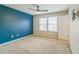 Bedroom featuring a blue accent wall, neutral carpet, and a ceiling fan at 4358 Grove Field Ct, Suwanee, GA 30024