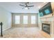 Bright living room featuring a fireplace, ceiling fan, and a wall-mounted television above a fireplace at 4358 Grove Field Ct, Suwanee, GA 30024