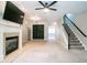 Bright living room featuring a fireplace, ceiling fan, staircase, and an eye-catching textured wall panel at 4358 Grove Field Ct, Suwanee, GA 30024