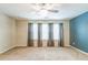 Living room with neutral carpet, light walls, and a row of windows with dark curtains at 4358 Grove Field Ct, Suwanee, GA 30024