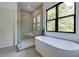 Elegant bathroom with a freestanding tub, glass shower, and a large window at 2745 S Bamby Ne Ln, Brookhaven, GA 30319