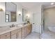 Bright bathroom features double vanity, modern mirrors, soaking tub, and glass shower at 2745 S Bamby Ne Ln, Brookhaven, GA 30319