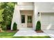 Inviting entryway with a light-stained door, black hardware, stylish exterior lighting, and manicured shrubs at 2745 S Bamby Ne Ln, Brookhaven, GA 30319