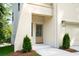 Welcoming front entrance with a light-stained door, modern lighting, and trimmed greenery, with light-colored brick at 2745 S Bamby Ne Ln, Brookhaven, GA 30319