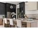 Kitchen island with seating and stylish lighting complemented by stainless steel appliances and dark cabinets at 2745 S Bamby Ne Ln, Brookhaven, GA 30319