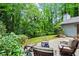 Relaxing backyard area featuring stone pavers and lots of seating, surrounded by lush trees at 895 Fawn Way, Marietta, GA 30068