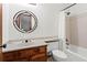 Cozy bathroom featuring a shower/tub combo, wood vanity, and round mirror at 895 Fawn Way, Marietta, GA 30068
