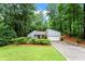 Charming home featuring a stone-accented facade, attached garage, and a lush, tree-filled landscape at 895 Fawn Way, Marietta, GA 30068