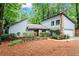 This home features a stone chimney, attached garage, landscaped front yard, and is surrounded by mature trees at 895 Fawn Way, Marietta, GA 30068