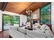 Open living room with stone fireplace, wood ceiling, and doors leading to a outdoor patio at 895 Fawn Way, Marietta, GA 30068