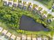 Aerial view showcases a community pond surrounded by lush greenery and well-manicured lawns at 1838 Lakeview Bend Way, Buford, GA 30519