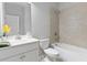Bright bathroom featuring a vanity sink and a combined tub and shower with neutral tile surround at 1838 Lakeview Bend Way, Buford, GA 30519
