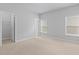 Bright bedroom with neutral carpet, two windows, and walk-in closet at 1838 Lakeview Bend Way, Buford, GA 30519