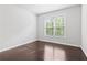 Cozy bedroom featuring hardwood floors and natural light from a window at 1838 Lakeview Bend Way, Buford, GA 30519