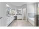 Well-lit main bathroom with double vanity, granite counters, soaking tub and glass shower at 1838 Lakeview Bend Way, Buford, GA 30519