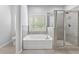 Attractive main bathroom with soaking tub, tiled shower, and natural light at 1838 Lakeview Bend Way, Buford, GA 30519