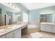 Bright bathroom featuring dual vanities, a soaking tub, and plenty of natural light at 223 Oak Grove Dr, Dallas, GA 30157
