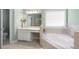 Bright bathroom featuring tile flooring, soaking tub, and a vanity with a large mirror at 223 Oak Grove Dr, Dallas, GA 30157