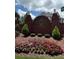 Charming Oak Grove Estates entrance featuring brick signage, manicured landscaping, and decorative lion statues at 223 Oak Grove Dr, Dallas, GA 30157