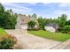 Exterior view of home, detached garage, driveway, and lush front yard at 223 Oak Grove Dr, Dallas, GA 30157