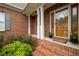 Charming brick front porch adorned with flowers and a decorative wood door at 223 Oak Grove Dr, Dallas, GA 30157