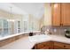 Bright kitchen area with white countertops, wood cabinets, tile backsplash and a dining area with backyard view at 223 Oak Grove Dr, Dallas, GA 30157