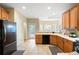 Spacious kitchen with wood cabinets, tile flooring, black appliances, and access to the backyard at 223 Oak Grove Dr, Dallas, GA 30157