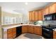 This updated kitchen features wood cabinetry, a black oven, and a view into the dining area at 223 Oak Grove Dr, Dallas, GA 30157