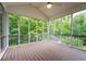 Inviting screened porch with dark floors, ceiling fan, and great wooded view at 223 Oak Grove Dr, Dallas, GA 30157