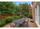 Elegant backyard patio with a dining table and seating area, surrounded by lush greenery and brick accents at 3032 Montclair Se Cir, Smyrna, GA 30080
