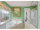 Bright bathroom features a soaking tub under a stained glass window and a glass shower at 3032 Montclair Se Cir, Smyrna, GA 30080