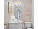 Quaint bathroom with rose wallpaper, a single sink vanity, and an ornate decorative mirror at 3032 Montclair Se Cir, Smyrna, GA 30080