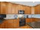 Well-lit kitchen features wooden cabinetry, black countertops and modern appliances at 3032 Montclair Se Cir, Smyrna, GA 30080