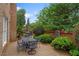 Outdoor patio features brick wall, dining set, umbrella, and manicured landscaping at 3032 Montclair Se Cir, Smyrna, GA 30080