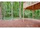 View from under deck to wooded lot with mulch covering in backyard at 3960 Rocmar Dr, Snellville, GA 30039