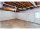 Unfinished basement features concrete flooring, white walls, exposed pipes, and exterior door at 3960 Rocmar Dr, Snellville, GA 30039