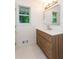 Bright bathroom with a wooden vanity, modern mirror, and natural light from the window at 3960 Rocmar Dr, Snellville, GA 30039