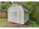 Storage shed in backyard with double doors, and light green wood paneling at 3960 Rocmar Dr, Snellville, GA 30039