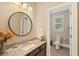 Bright bathroom with granite countertops, modern fixtures, round mirror, and view into an additional toilet area at 4224 Dogwood Bend Park, Duluth, GA 30096