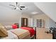 Angled bedroom features two twin beds with red blankets, a ceiling fan, and carpeted floors at 4224 Dogwood Bend Park, Duluth, GA 30096